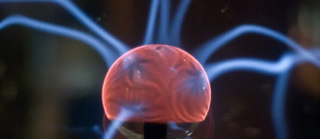Plasma globe emitting electric arcs, representing concepts of neuroscience and sales dynamics.