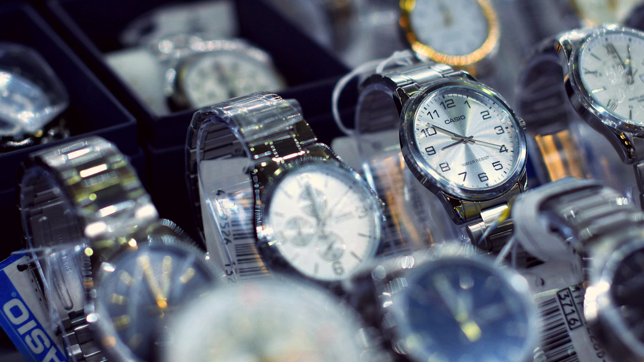 A close-up of several wristwatches laid out on a display surface, representing the street vendor watch story at the heart of this article on understanding customer problems.