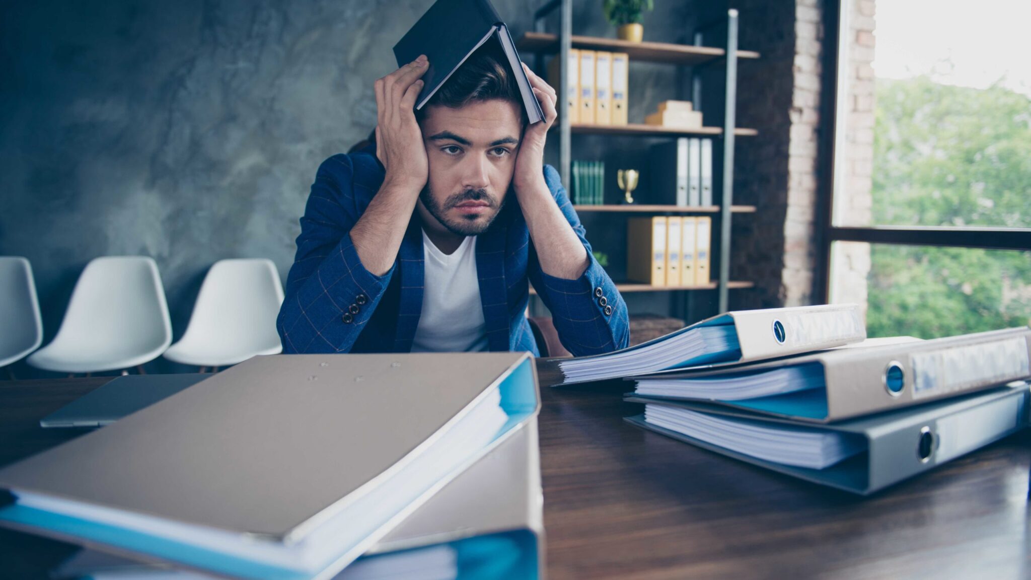 A sales professional reviewing product documentation at a desk, representing the tension between deep product knowledge and customer-centered communication.